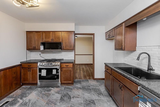 716 Maple St, Perrysburg, OH 43551 - kitchen featuring appliances with stainless steel finishes, dark countertops, decorative backsplash, and brown cabinets