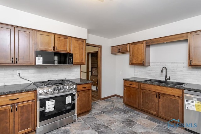 716 Maple St, Perrysburg, OH 43551 - kitchen featuring stainless steel appliances, decorative backsplash, dark stone finish flooring, and brown cabinetry