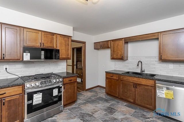 716 Maple St, Perrysburg, OH 43551 - kitchen with appliances with stainless steel finishes, backsplash, dark stone finish flooring, brown cabinets, and dark stone counters