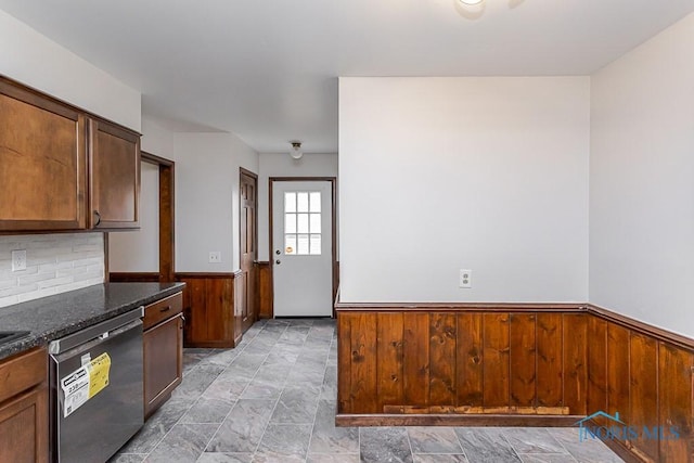 716 Maple St, Perrysburg, OH 43551 - kitchen with dishwasher, a wainscoted wall, wooden walls, dark stone countertops, and tasteful backsplash