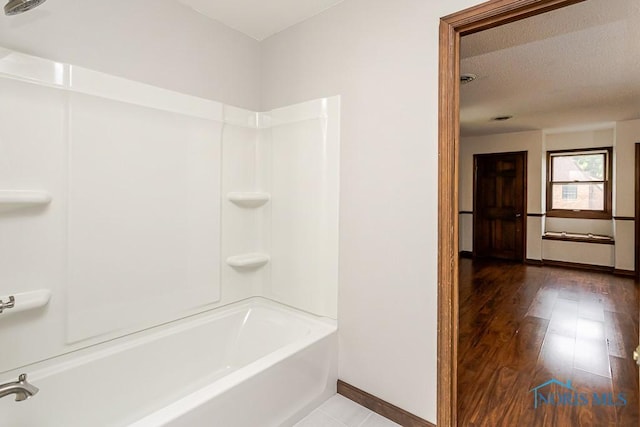 716 Maple St, Perrysburg, OH 43551 - bathroom with tub / shower combination, wood finished floors, and a textured ceiling