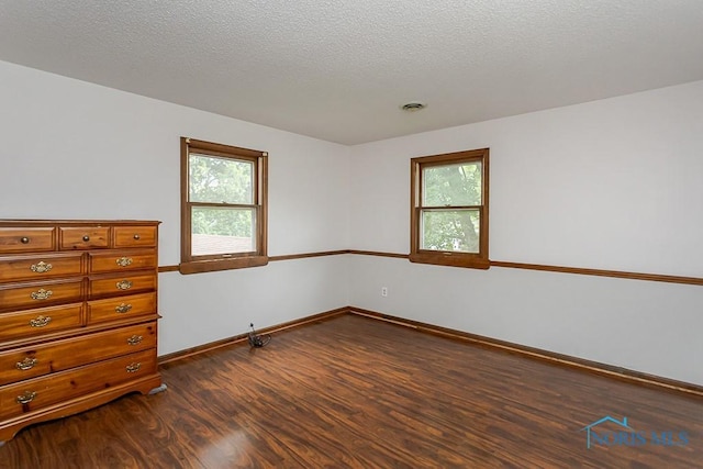 716 Maple St, Perrysburg, OH 43551 - unfurnished room with dark wood-style flooring, healthy amount of natural light, and a textured ceiling