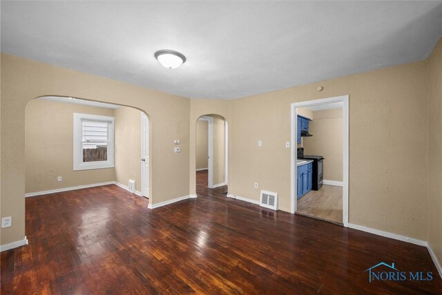 902 Coventry Ave, Toledo, OH 43607 - unfurnished room with arched walkways, wood finished floors, and baseboards