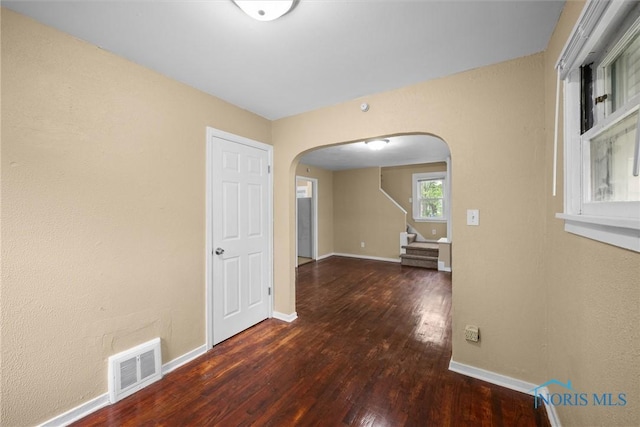 902 Coventry Ave, Toledo, OH 43607 - spare room featuring arched walkways, wood finished floors, baseboards, and stairway