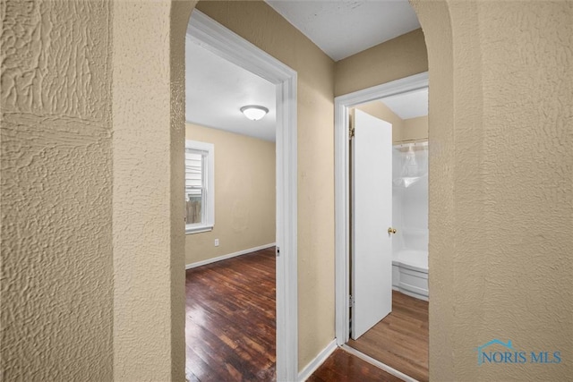 902 Coventry Ave, Toledo, OH 43607 - corridor with wood finished floors, arched walkways, a textured wall, and baseboards
