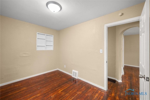 902 Coventry Ave, Toledo, OH 43607 - spare room with arched walkways, wood finished floors, and baseboards