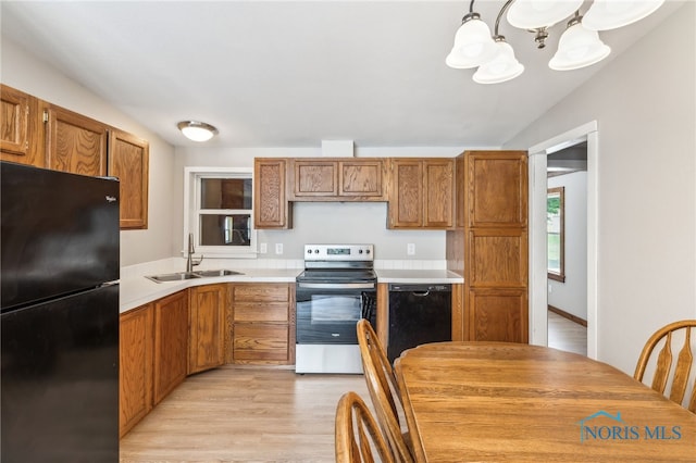 304 Wise St, Forest, OH 45843 - kitchen with black appliances, a chandelier, light countertops, brown cabinets, and light wood finished floors