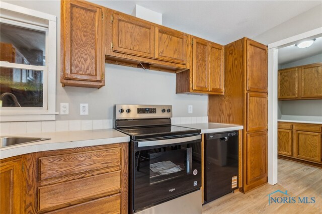 304 Wise St, Forest, OH 45843 - kitchen with stainless steel electric range, dishwasher, light wood-type flooring, and brown cabinets