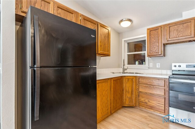 304 Wise St, Forest, OH 45843 - kitchen with freestanding refrigerator, stainless steel electric range, light countertops, and brown cabinetry