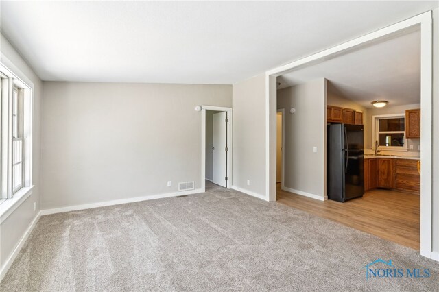 304 Wise St, Forest, OH 45843 - unfurnished living room featuring light colored carpet and a sink