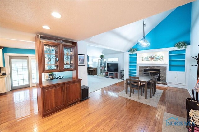 6975 Ramblehurst Rd, Sylvania, OH 43560 - dining area with a fireplace, light wood-style flooring, healthy amount of natural light, recessed lighting, and vaulted ceiling
