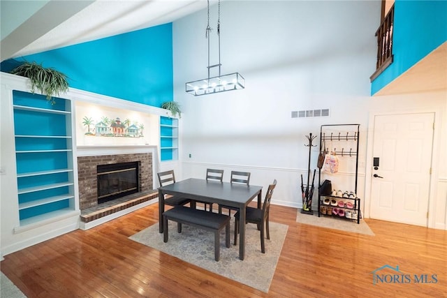 6975 Ramblehurst Rd, Sylvania, OH 43560 - dining space with high vaulted ceiling, a fireplace, wood finished floors, and built in features