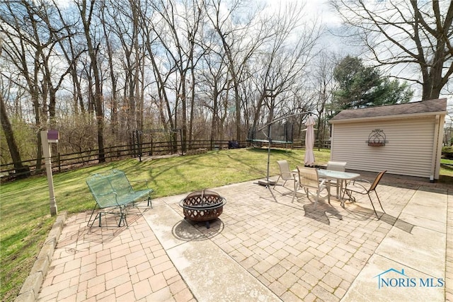 6975 Ramblehurst Rd, Sylvania, OH 43560 - fenced backyard with a trampoline, a fire pit, a patio area, and outdoor dining space