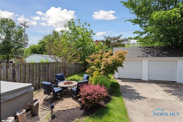 2707 Gunckel Blvd, Toledo, OH 43606 - view of yard with a hot tub, an outdoor fire pit, a detached garage, and an outbuilding