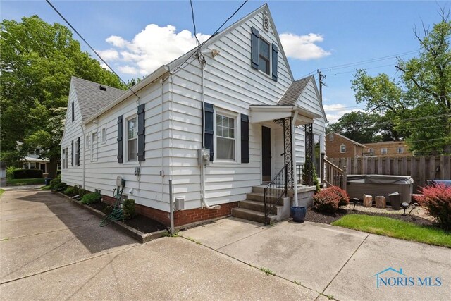 2707 Gunckel Blvd, Toledo, OH 43606 - view of front of house featuring a hot tub, a shingled roof, and a patio