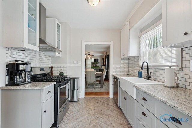 2707 Gunckel Blvd, Toledo, OH 43606 - kitchen with stainless steel appliances, decorative backsplash, white cabinetry, and light stone countertops