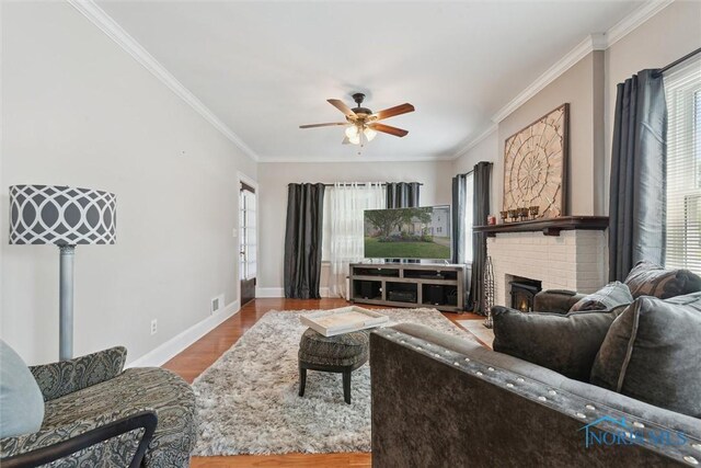 2707 Gunckel Blvd, Toledo, OH 43606 - living room featuring ceiling fan, healthy amount of natural light, wood finished floors, ornamental molding, and a brick fireplace