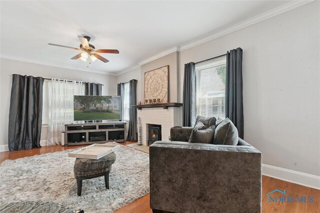 2707 Gunckel Blvd, Toledo, OH 43606 - living room with a ceiling fan, crown molding, a brick fireplace, and wood finished floors