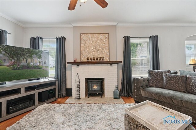 2707 Gunckel Blvd, Toledo, OH 43606 - living room with wood finished floors, a ceiling fan, ornamental molding, arched walkways, and a wood stove