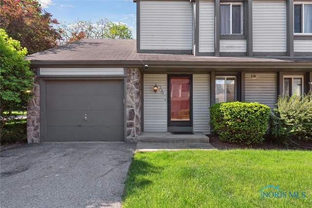 2540 Plum Leaf Ln, Toledo, OH 43614 - view of front of house with driveway, an attached garage, and a front yard