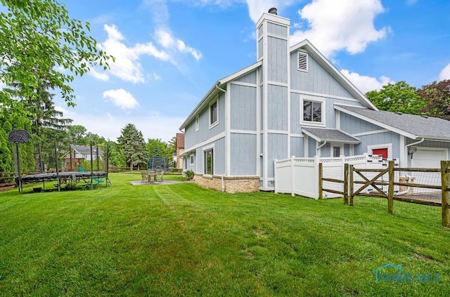 2709 Derby Rd, Ottawa Hills, OH 43615 - back of house with a trampoline, a chimney, and an attached garage