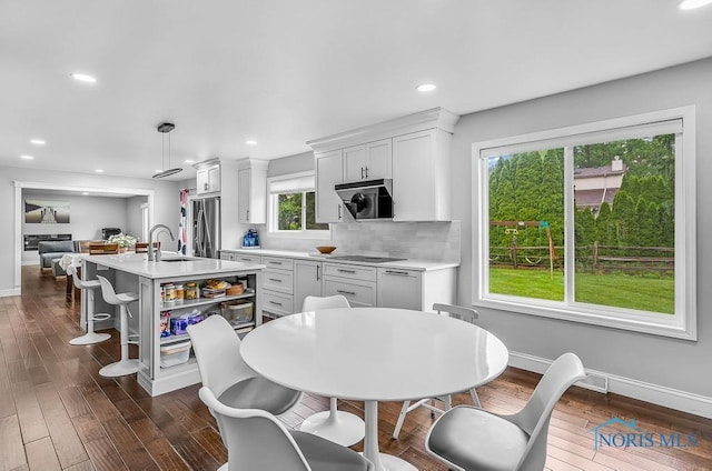 2709 Derby Rd, Ottawa Hills, OH 43615 - kitchen featuring light countertops, stainless steel refrigerator with ice dispenser, black electric stovetop, dark wood finished floors, and recessed lighting
