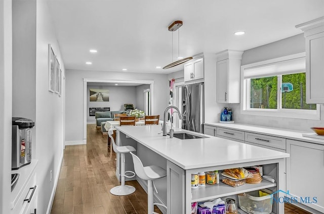 2709 Derby Rd, Ottawa Hills, OH 43615 - kitchen with stainless steel refrigerator with ice dispenser, light countertops, open shelves, wood finished floors, and recessed lighting