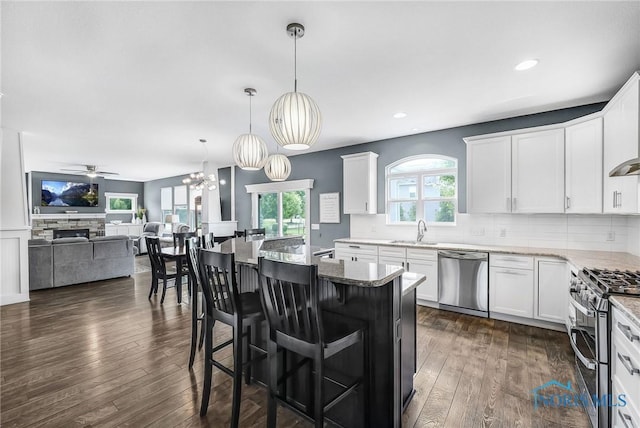 9211 Stable Creek Ct, Sylvania, OH 43560 - kitchen with appliances with stainless steel finishes, tasteful backsplash, a ceiling fan, white cabinetry, and dark wood-style flooring