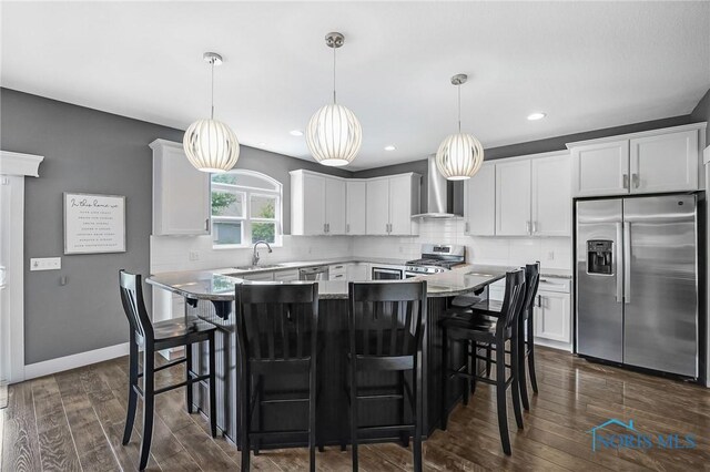 9211 Stable Creek Ct, Sylvania, OH 43560 - kitchen featuring stainless steel appliances, wall chimney exhaust hood, dark wood-style floors, white cabinets, and backsplash