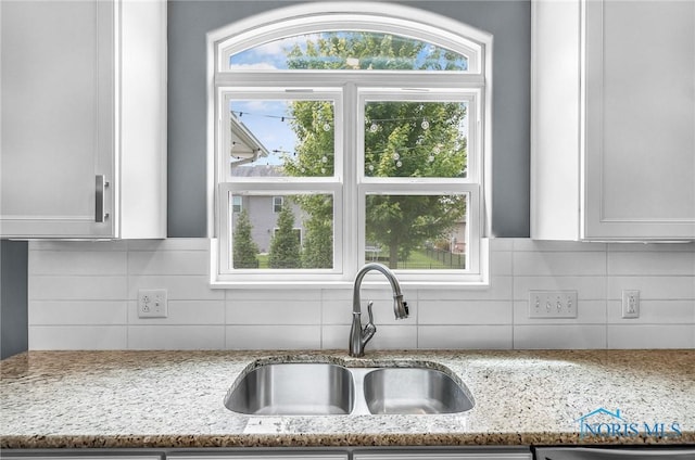9211 Stable Creek Ct, Sylvania, OH 43560 - kitchen featuring tasteful backsplash, light stone countertops, white cabinetry, and healthy amount of natural light