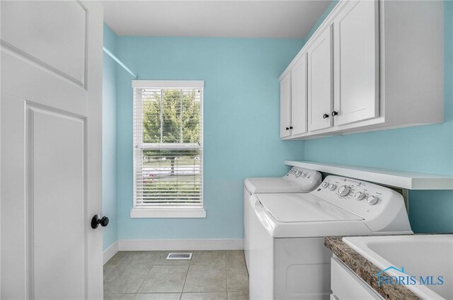 9211 Stable Creek Ct, Sylvania, OH 43560 - laundry area featuring cabinet space, separate washer and dryer, and light tile patterned floors