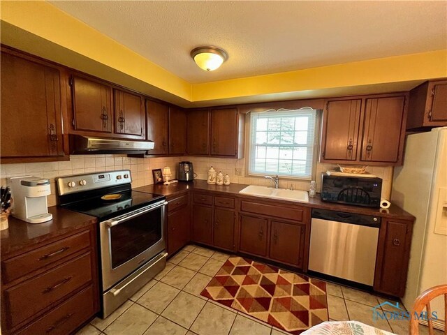 6312 Meadowlark Ln, Payne, OH 45880 - kitchen featuring appliances with stainless steel finishes, under cabinet range hood, dark countertops, and a textured ceiling