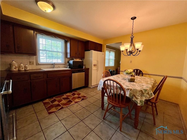 6312 Meadowlark Ln, Payne, OH 45880 - kitchen featuring white refrigerator with ice dispenser, black microwave, dishwasher, a chandelier, and light tile patterned flooring