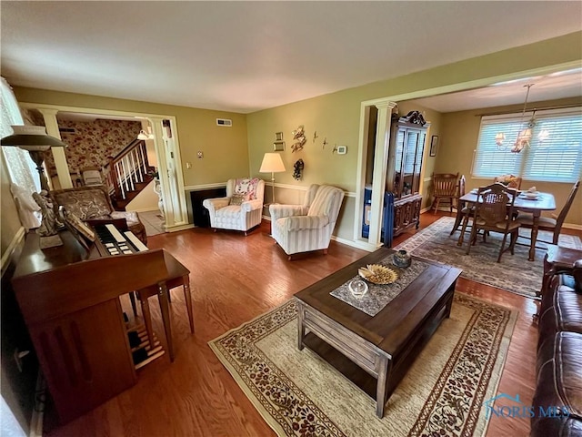 6312 Meadowlark Ln, Payne, OH 45880 - living room with ornate columns, wood finished floors, a chandelier, and stairway
