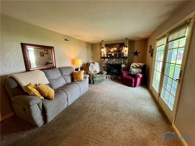 6312 Meadowlark Ln, Payne, OH 45880 - living area featuring carpet flooring, a stone fireplace, a textured wall, and a textured ceiling