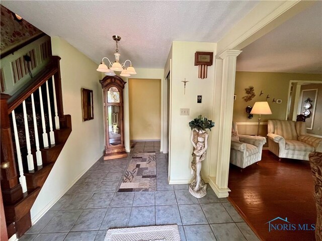 6312 Meadowlark Ln, Payne, OH 45880 - foyer with a chandelier, a textured ceiling, stairs, and dark tile patterned flooring
