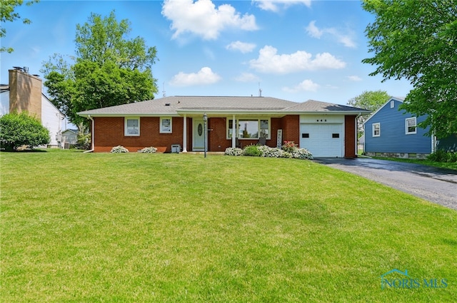 642 Edith Ave, Findlay, OH 45840 - single story home featuring a garage, driveway, covered porch, brick siding, and a front yard