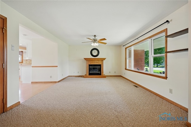 642 Edith Ave, Findlay, OH 45840 - unfurnished living room with light colored carpet, a ceiling fan, and a glass covered fireplace