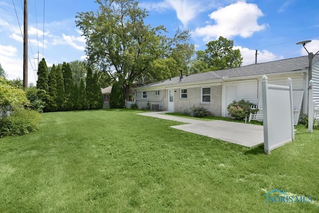 5022 Stengel Ave, Toledo, OH 43614 - back of house featuring a patio area, a lawn, brick siding, and a shingled roof