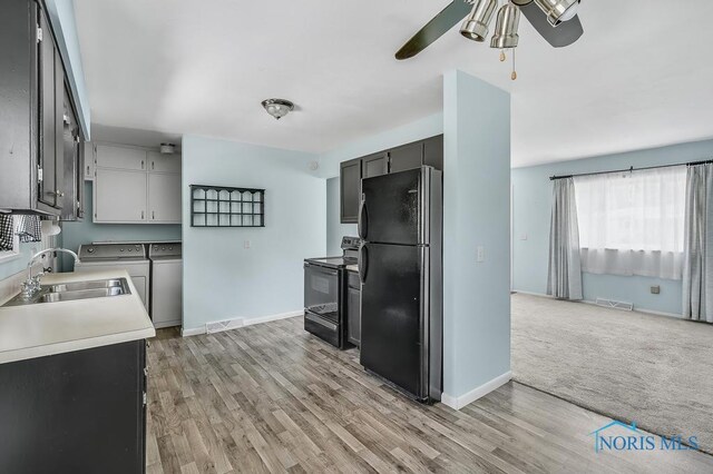 5022 Stengel Ave, Toledo, OH 43614 - kitchen featuring black appliances, washer and clothes dryer, ceiling fan, light wood-style floors, and light countertops