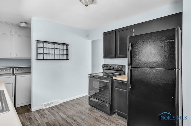 5022 Stengel Ave, Toledo, OH 43614 - kitchen with black appliances, independent washer and dryer, light wood-type flooring, and light countertops