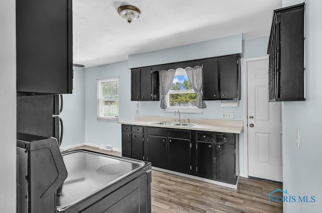 5022 Stengel Ave, Toledo, OH 43614 - kitchen featuring dark cabinets, light wood-style flooring, and light countertops