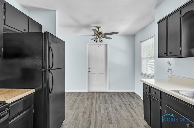 5022 Stengel Ave, Toledo, OH 43614 - kitchen featuring freestanding refrigerator, ceiling fan, light countertops, light wood-type flooring, and dark cabinets