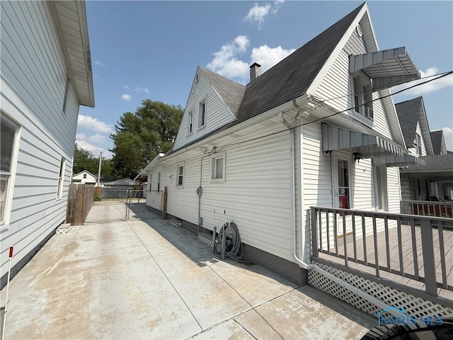 831 Butler St, Toledo, OH 43605 - view of property exterior with roof with shingles, a chimney, and a gate
