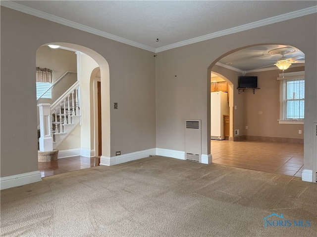 831 Butler St, Toledo, OH 43605 - tiled spare room with carpet, ceiling fan, ornamental molding, arched walkways, and stairway