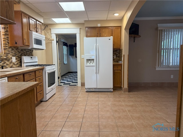 831 Butler St, Toledo, OH 43605 - kitchen featuring white appliances, brown cabinets, tasteful backsplash, arched walkways, and a paneled ceiling