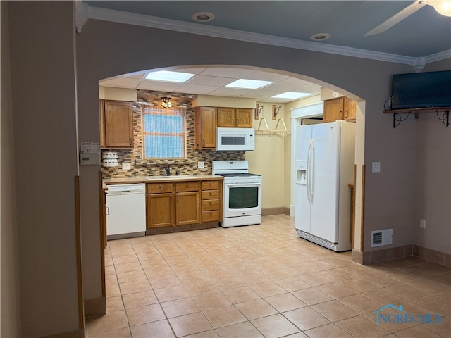 831 Butler St, Toledo, OH 43605 - kitchen with white appliances, arched walkways, a ceiling fan, brown cabinets, and decorative backsplash