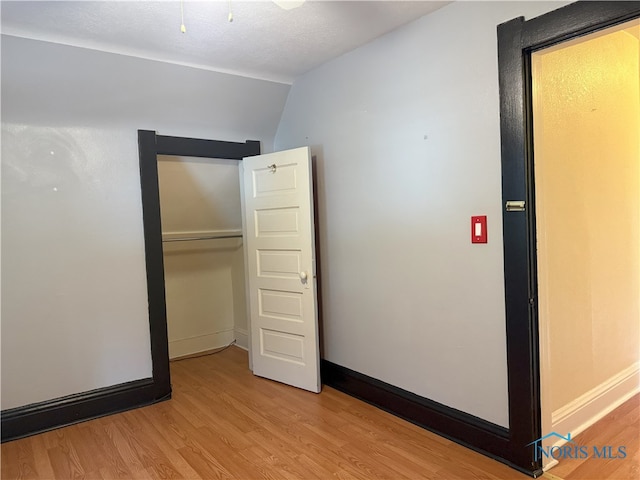 831 Butler St, Toledo, OH 43605 - unfurnished bedroom with light wood finished floors, a closet, and lofted ceiling