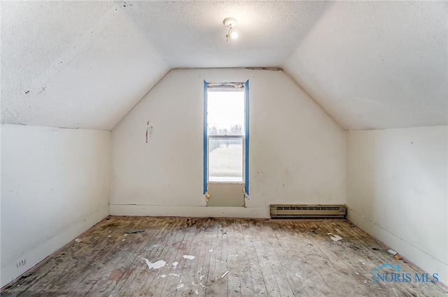 225 2nd St, Latty, OH 45855 - additional living space featuring a baseboard radiator, hardwood / wood-style flooring, vaulted ceiling, and a textured ceiling