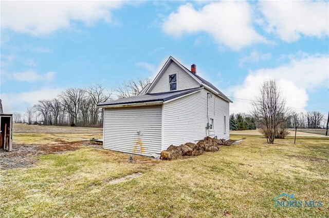225 2nd St, Latty, OH 45855 - view of property exterior featuring a lawn and a chimney